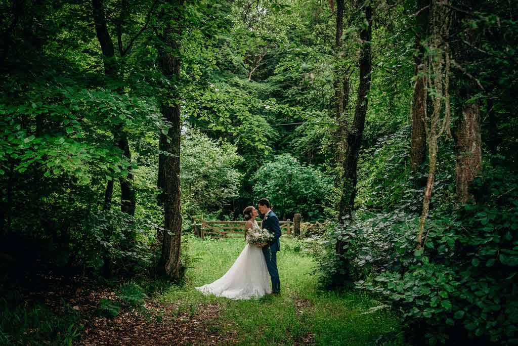 Bride and bridgroom in green wooded area