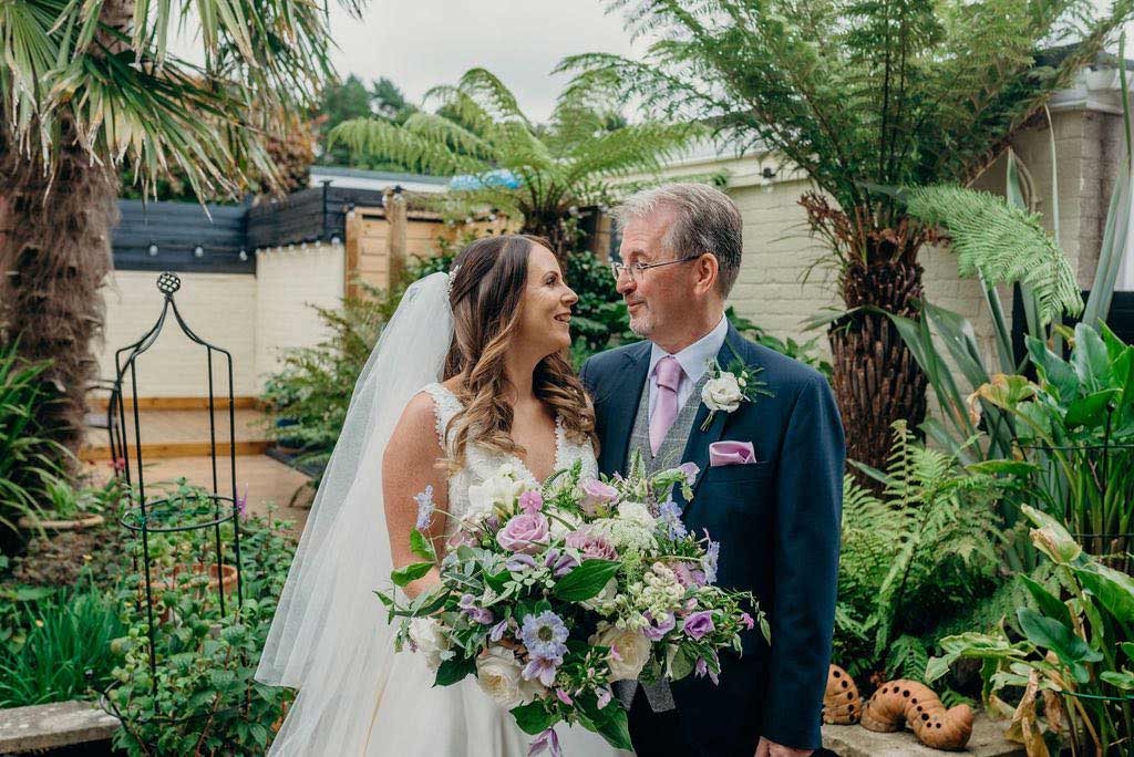 Bride and her father with pink wedding bouquet