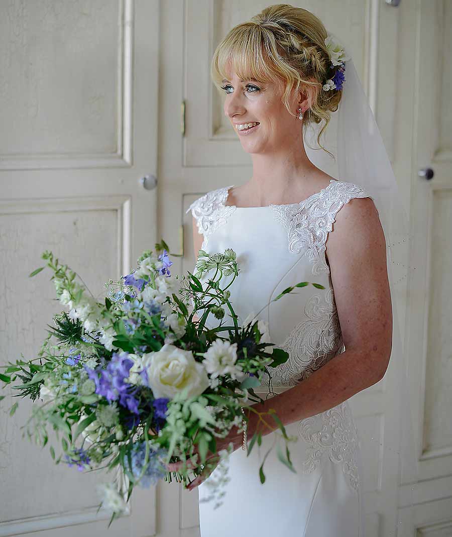 Bride holding blue and white bouquet