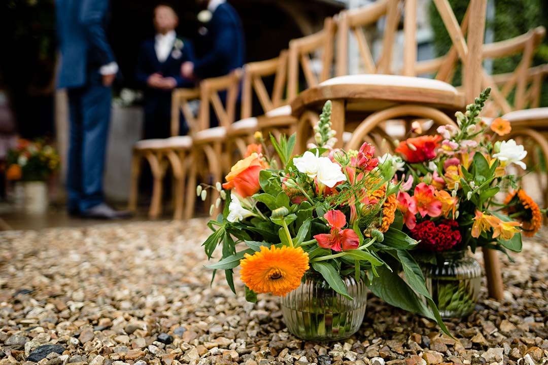 Vase of orange wedding flowers
