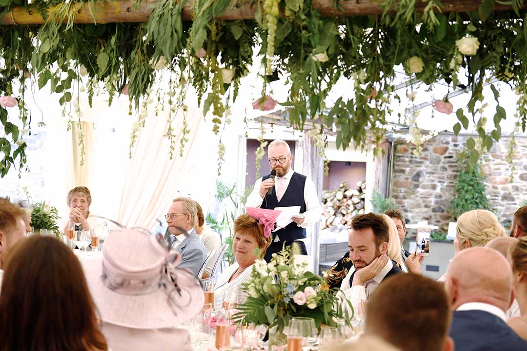 Wedding party under suspended wedding flowers